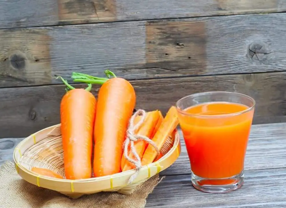 Glass of carrot juice and fresh carrots