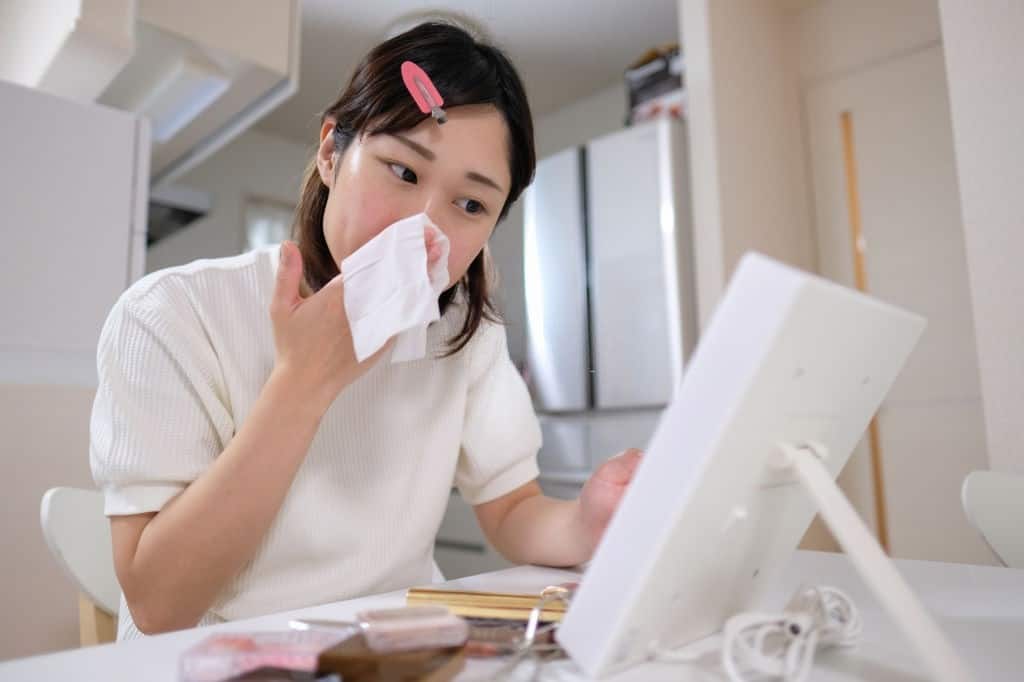 Young woman removing her makeup 